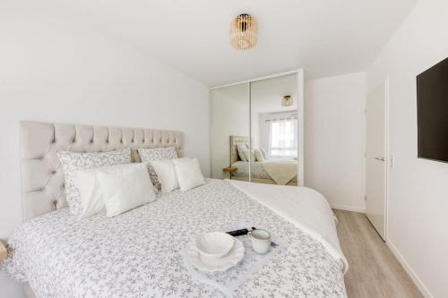 - une chambre blanche avec un grand lit blanc et une plaque de cuisson dans l'établissement Appartement Moderne T2 Proche PARIS Parking, à Bondy