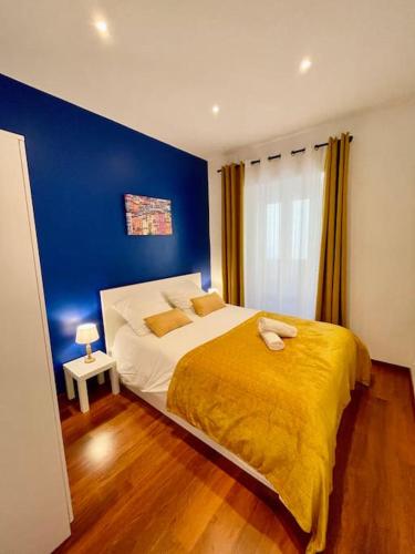 une chambre avec un grand lit avec un mur bleu dans l'établissement Le Village - cosy flat 5 min walk away from sea, à Nice