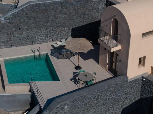 an overhead view of a teddy bear and an umbrella next to a pool at Bay View Residences Santorini in Akrotiri