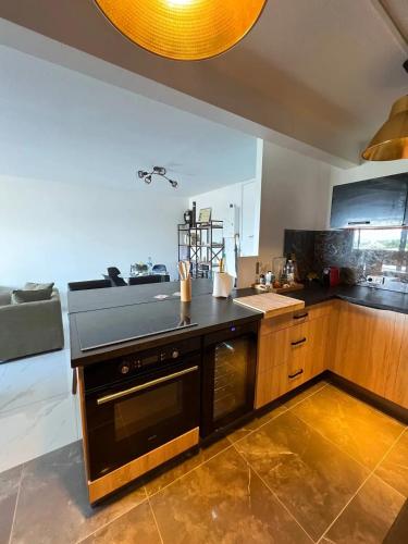 a kitchen with a black counter top and a stove at Appartement confortable à Ducos, 55 m² avec terrasse in Ducos