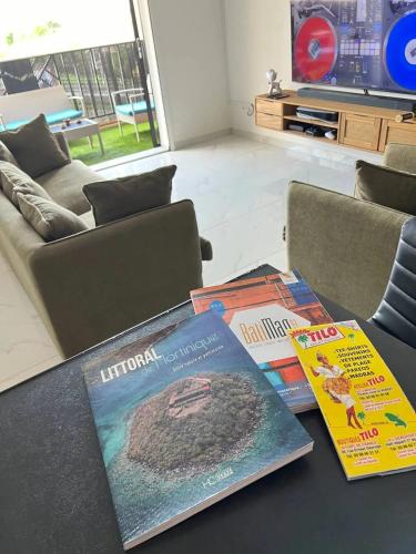 three books sitting on a table in a living room at Appartement confortable à Ducos, 55 m² avec terrasse in Ducos