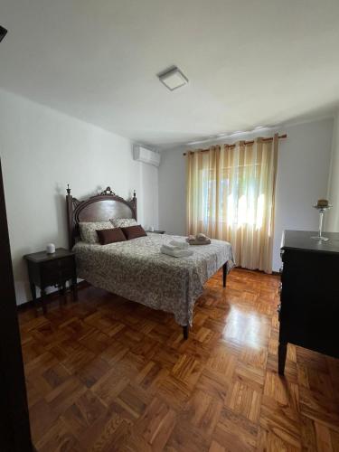 a bedroom with a bed and a wooden floor at Casa do Tonito in Carregal do Sal