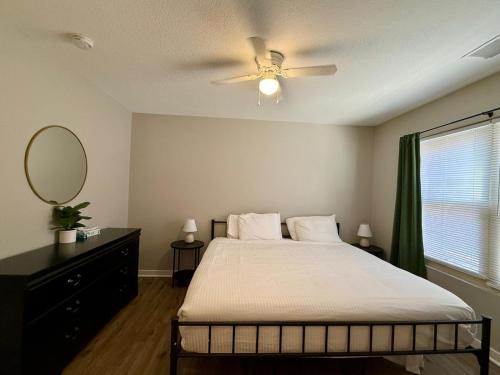 1 dormitorio con 1 cama con ventilador de techo y espejo en Cozy Aksarben Living-close to I-80 & WFH desk, en Omaha