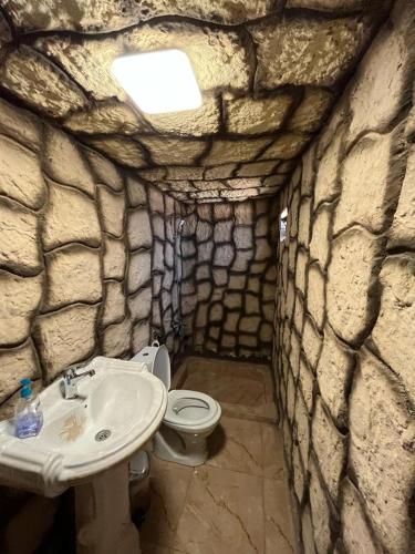 a stone bathroom with a sink and a toilet at Al -Nawatef Eco Lodge- Dana Nature Reserve in Dana