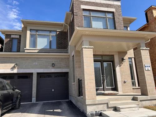 a house with a car parked in front of it at Ravine Retreat - 3RM Suite, 2BD, 1 WR, Pool, Sauna in Whitby