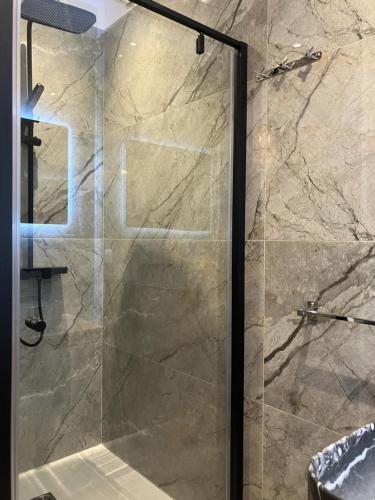 une douche avec une porte vitrée dans une salle de bain dans l'établissement Villa luxury vue mer au centre-ville de Porto Vecchio, à Porto-Vecchio