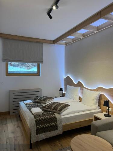 a bedroom with a large bed and a window at Privatni Studio Apartman RIO 028 u sklopu HOTEL VUČKO JAHORINA in Jahorina
