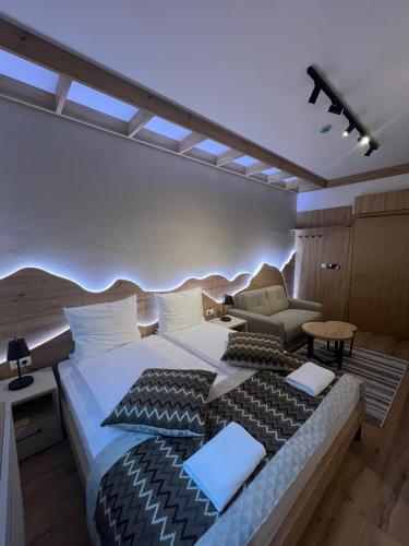 a bedroom with a large bed and a couch at Privatni Studio Apartman RIO 028 u sklopu HOTEL VUČKO JAHORINA in Jahorina