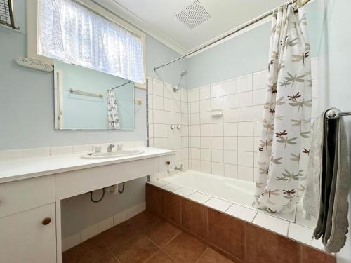 a bathroom with a tub and a sink and a shower at The Secret Waypoint - Kalbarri, WA in Kalbarri