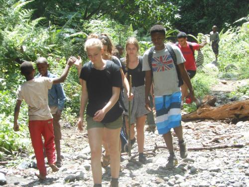 um grupo de pessoas a caminhar por um trilho rochoso em Runako Lodge em Arusha