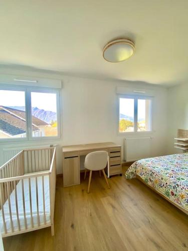 - une chambre avec un lit, un bureau et un lit bébé dans l'établissement VILLA VUE LAC -3 chambres jardin-proche du lac et du Centre-ville , 2 places parking, à Mouxy