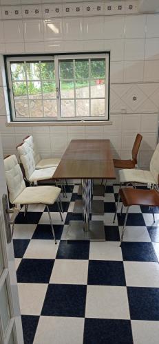 a meeting room with a table and chairs on a checkered floor at Quarto privado 6 in Famões