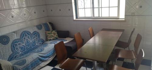 a room with a table and a couch and a table and chairs at Quarto privado 6 in Famões