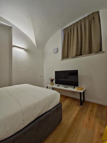 a bedroom with a bed and a flat screen tv at Major House - Luxury Apartments in Rome by Hostand in Rome