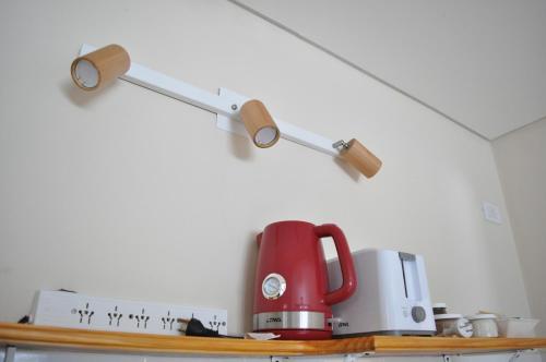 a red coffee pot sitting on top of a shelf at Aparts Merkaba in El Chalten