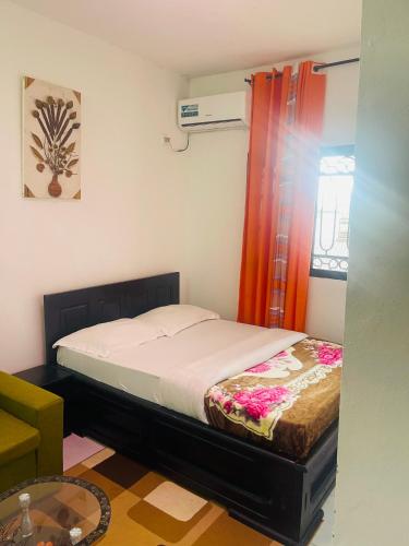 a small bedroom with a bed and a window at Residence SVET in Kribi