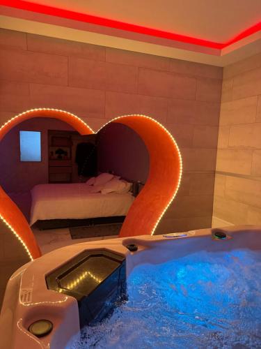 une chambre d'hôtel avec un bain à remous et un lit dans l'établissement Lescapade, à Luxeuil-les-Bains