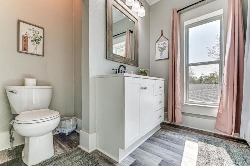 a bathroom with a toilet and a sink and a window at Near Campus and Casino Family-Friendly Durant Home! in Durant