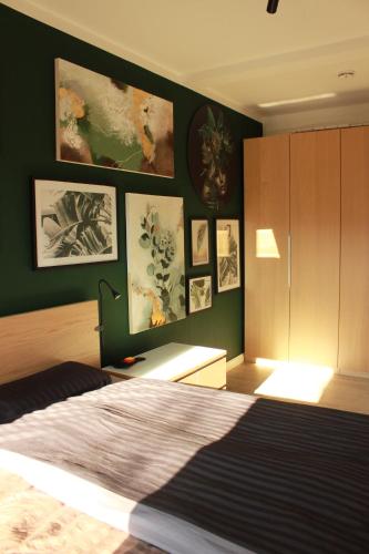 a bedroom with a bed and some pictures on the wall at 3 Raum Businessapartment in der Kulturhauptstadt 2025 #Kaffeevollautomat #65 Zoll TV mit Surround Soundanlage in Chemnitz