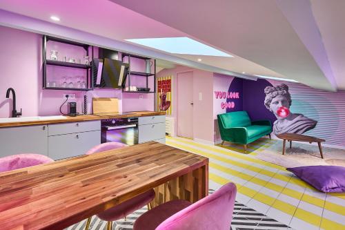 une cuisine avec une table et une chaise verte dans l'établissement Appart InstaGood by La Villa Orange, à Carcassonne