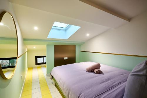 une chambre avec un lit et une lucarne dans l'établissement Appart InstaGood by La Villa Orange, à Carcassonne