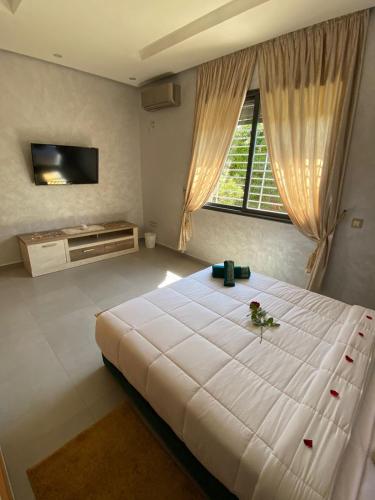 a bedroom with a large white bed and a window at charmante villa de luxe à Marrakech in Marrakesh
