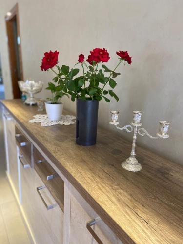 a table with a vase with red flowers on it at charmante villa de luxe à Marrakech in Marrakesh