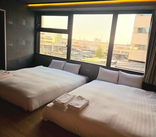 two beds in a room with a large window at ピンポンホテル&キャビン pin pon hotel & cabin in Shunan
