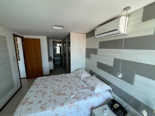 a bedroom with a bed and a wall with aperature at Apartamento Luxor Tambaú in João Pessoa