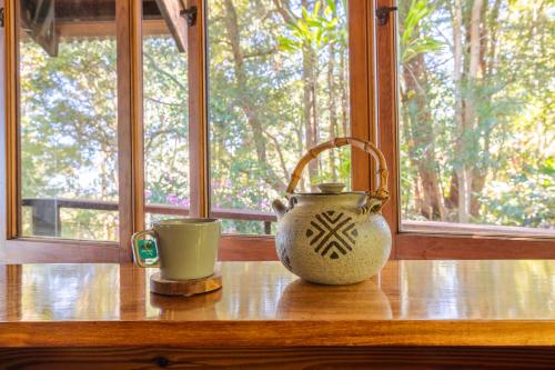 a vase and a cup sitting on a window sill at Krishna Farm Retreat in Coolabine