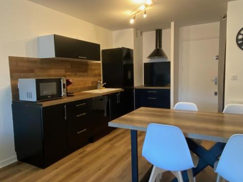 - une cuisine avec une table en bois et des chaises blanches dans l'établissement EDEN CATALAN 5 personnes meublé tourisme 