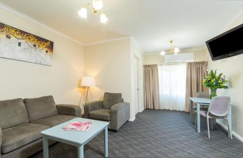 a living room with a couch and a table at Adelaide Royal Coach in Adelaide