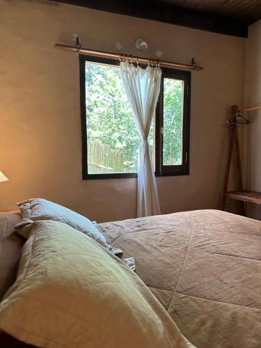 a bedroom with a bed and a window at Los ciruelos - Casas de Motaña in Tafí del Valle