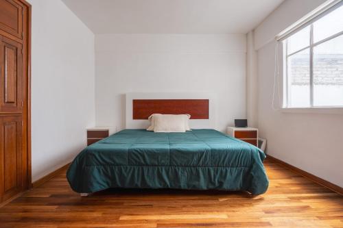 a bedroom with a bed with a green blanket at Nice private studio. Polanco area :) in Mexico City