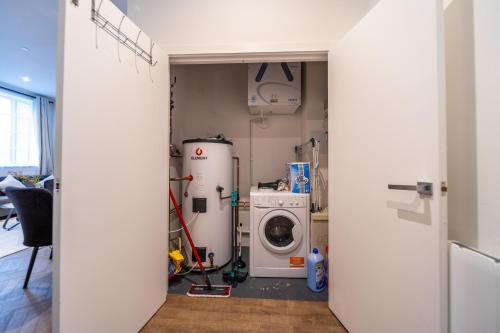 a laundry room with a washing machine and a washer at The Essex Apartments - Ashby House in Chelmsford