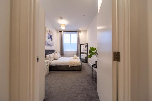 a bedroom with a bed and a window at The Essex Apartments - Ashby House in Chelmsford