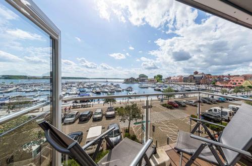 a balcony with chairs and a marina with boats at MueritzAusblick - Altstadtidyll mit Hafenblick in Waren