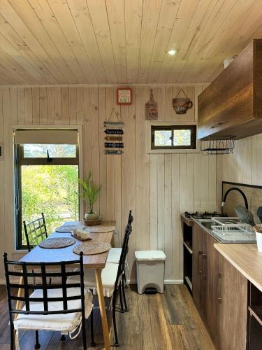 a kitchen with a table and chairs in a room at Cabaña Luna de Lobos in Pichilemu