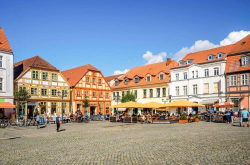 a town square with buildings and people walking around at MüritzLounge am Seeufer in Waren