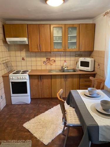 a kitchen with a table and a white stove top oven at Chata Jelka in Tatranska Strba
