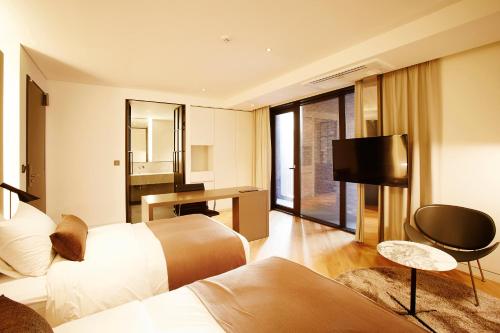 a hotel room with two beds and a desk at MD HOTEL Dongtan in Hwaseong