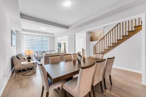 a dining room and living room with a table and chairs at Executive Brand New House 5 Bedrooms and Office in Cambridge