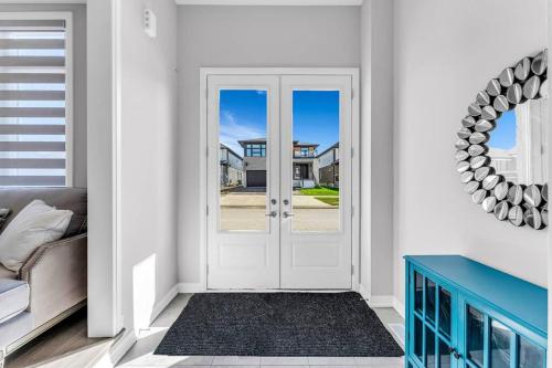 a white door in a living room with a couch at Executive Brand New House 5 Bedrooms and Office in Cambridge
