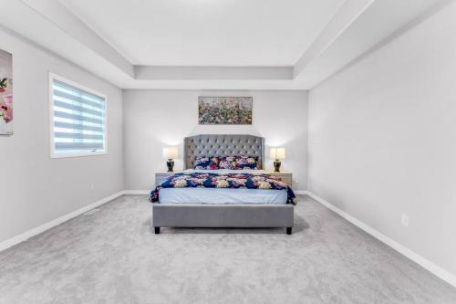 a bedroom with a bed in a white room at Executive Brand New House 5 Bedrooms and Office in Cambridge