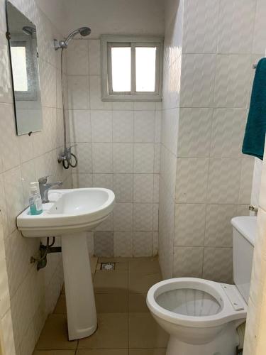 un bagno bianco con lavandino e WC di studio meublé a Dakar