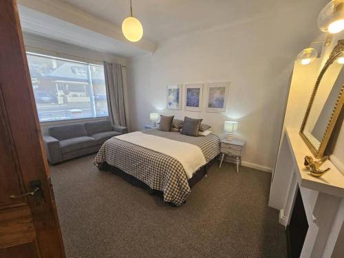 a hotel room with a bed and a couch at RoseIris Cottage - City Charm in Central West Hobart in West Hobart