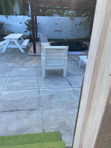 two white chairs and a table on a patio at Beautiful Vacation Home in Ocho Rios