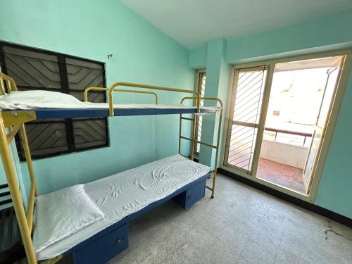 FortThe Kaya Backpackers Hostel的有两张双层床和一扇窗户的房间