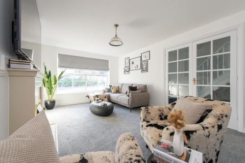 a living room with two chairs and a couch at Stunning 5 bedroom detached house in Hornchurch in Romford