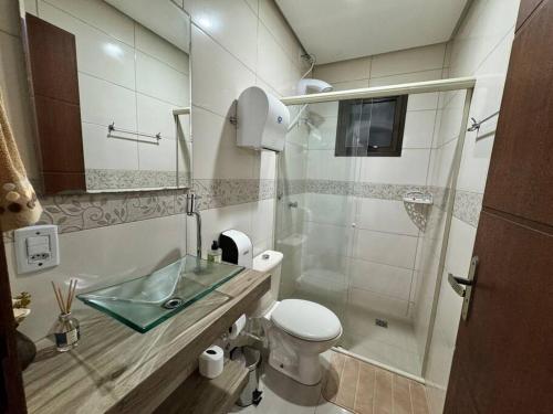 a bathroom with a toilet and a glass sink at Duplex Central Rio Grande in Rio Grande